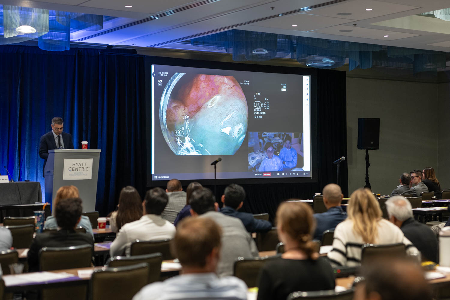 Live stream of colonoscopy being broadcast on screen during conference